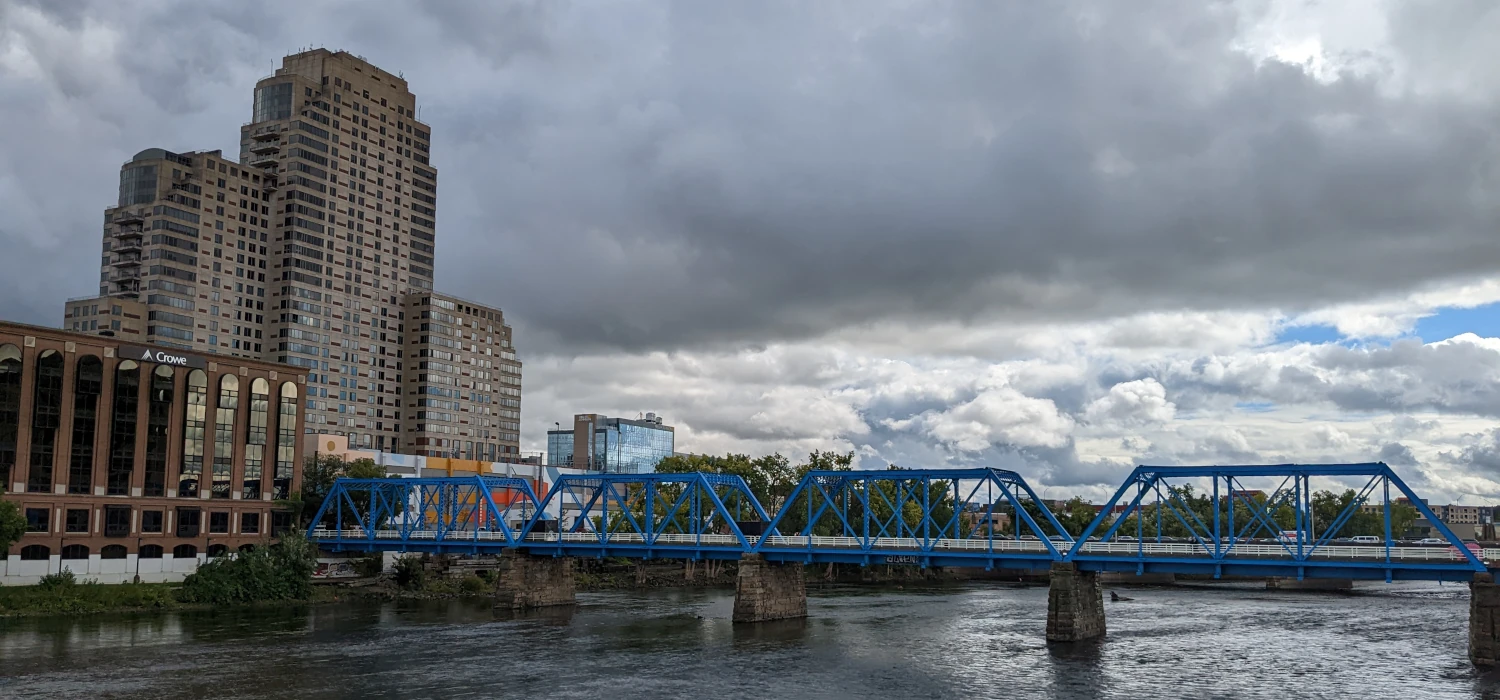 Photo of a city with blue bridge over a river.